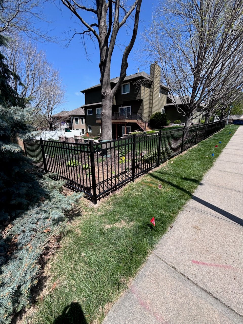 Black ornamental aluminum fence in residential front yard — curb appeal that closes