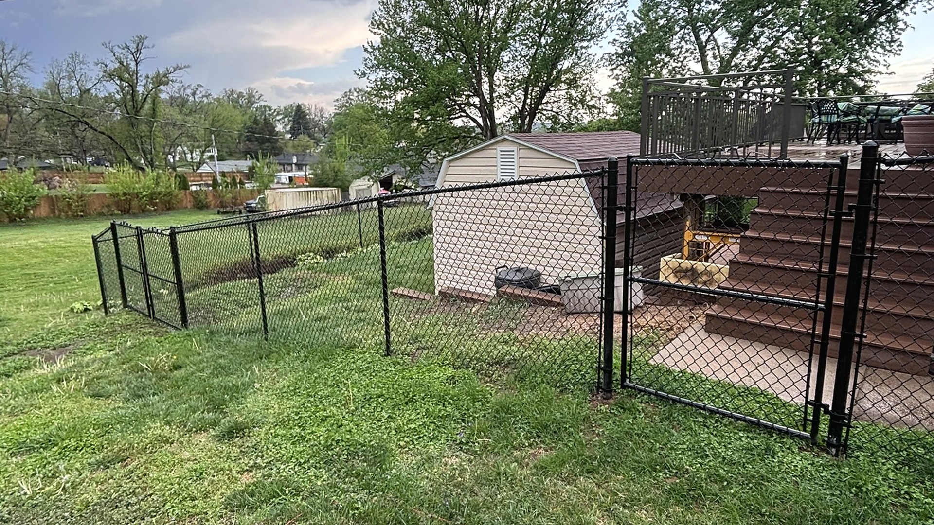 Black residential chain link fence keeping the yard contained